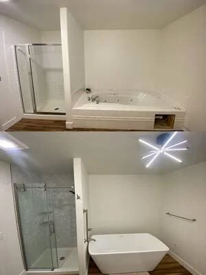 Remodeled bathroom with gray tile shower, sliding glass door, freestanding white tub, and wood-look flooring